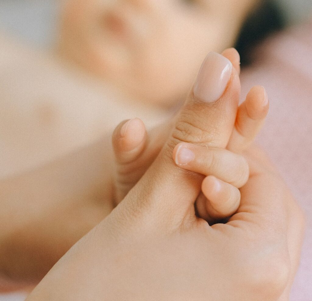 A close-up of a mother gently holding her baby's hand, symbolizing love and care.